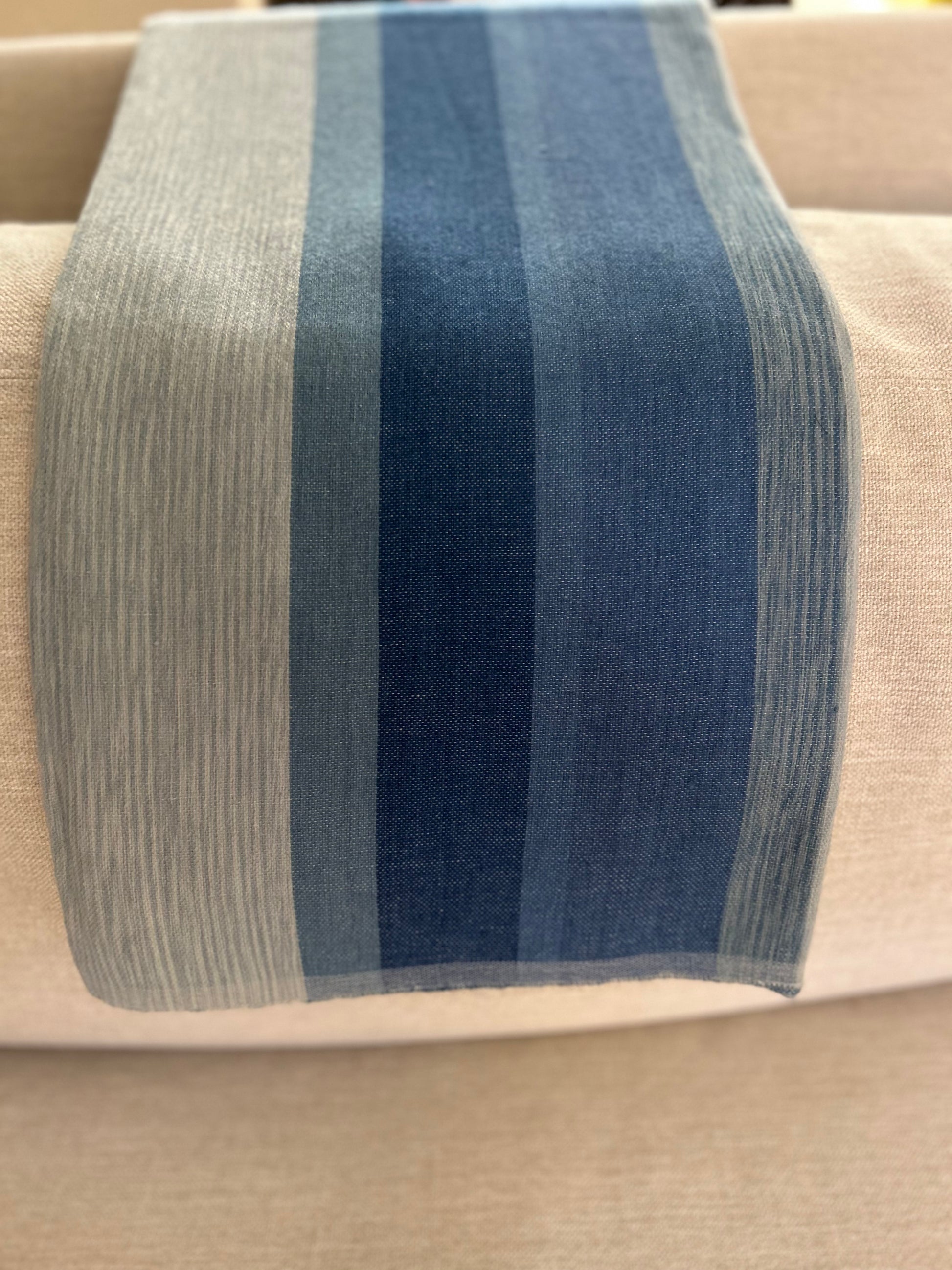 blue striped wool and cotton shawl on a beige surface