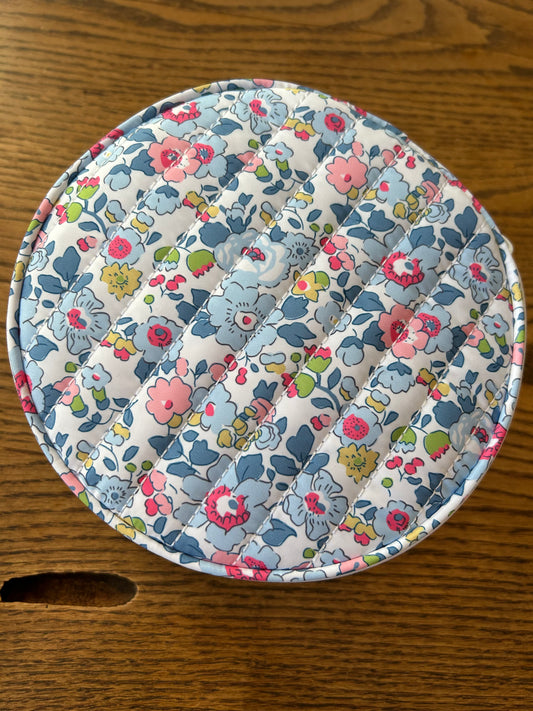 Floral patterned travel jewelry case on a wooden surface