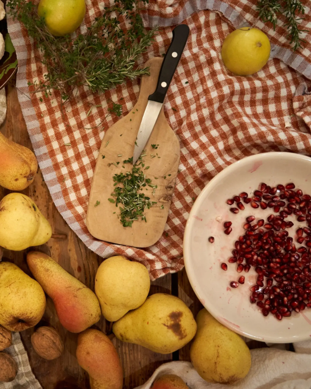 Checkered hand-spun linen tea towel shown with assorted fall foods and herbs
