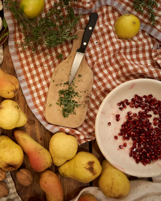 Checkered hand-spun linen tea towel shown with assorted fall foods and herbs